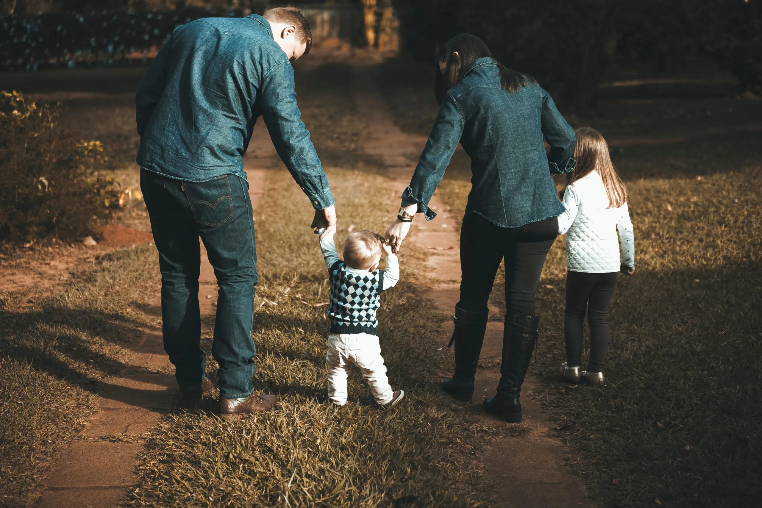 picture of parents holding young boys hand walking up a road